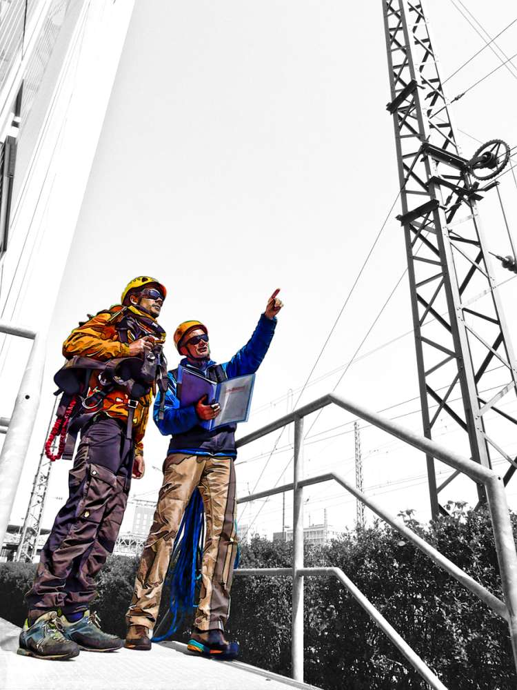 Zwei Personen bei der Planung von Höhenarbeiten im Gespräch