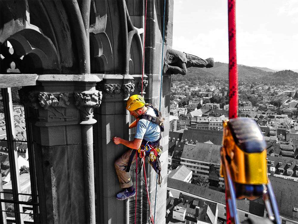 Kletterer bei der Durchführung von Revisionsarbeiten an einer Kirche